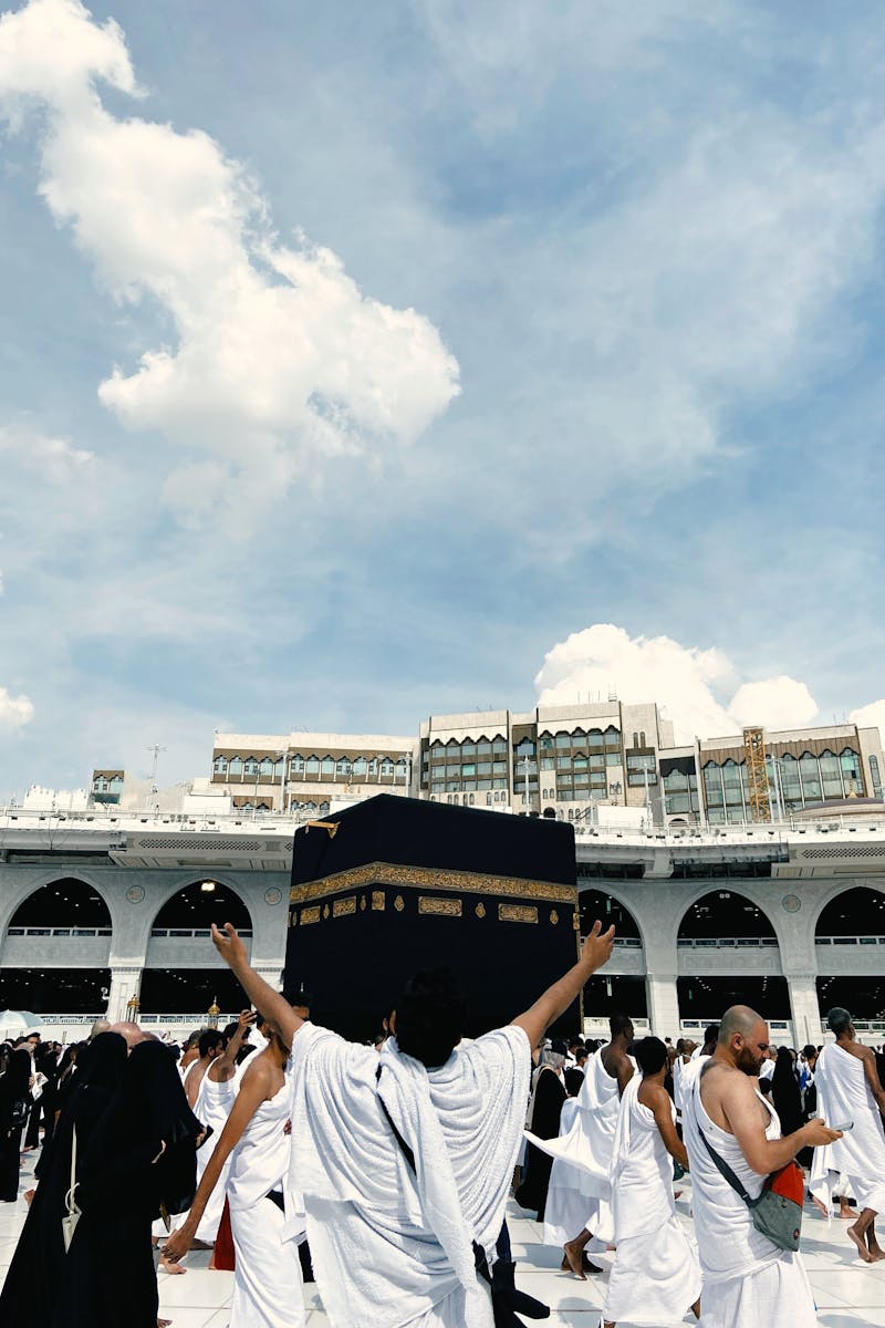 A large crowd of pilgrims performing Hajj at the Kaaba, showcasing religious devotion and unity.